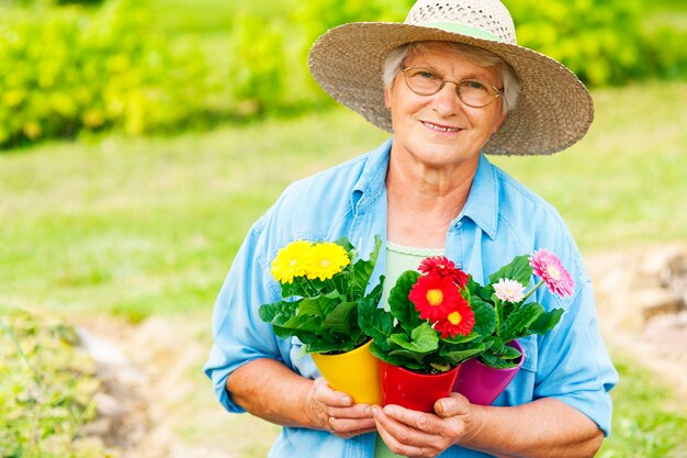 Mujer mayor, con, flores, en, jardín