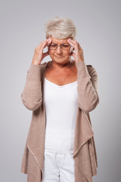 Mujer mayor con gran dolor de cabeza