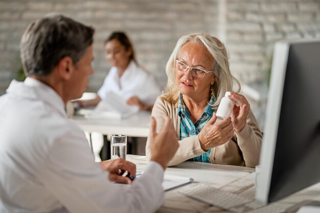 Mujer mayor hablando con su médico sobre sus medicamentos recetados durante las consultas en la clínica