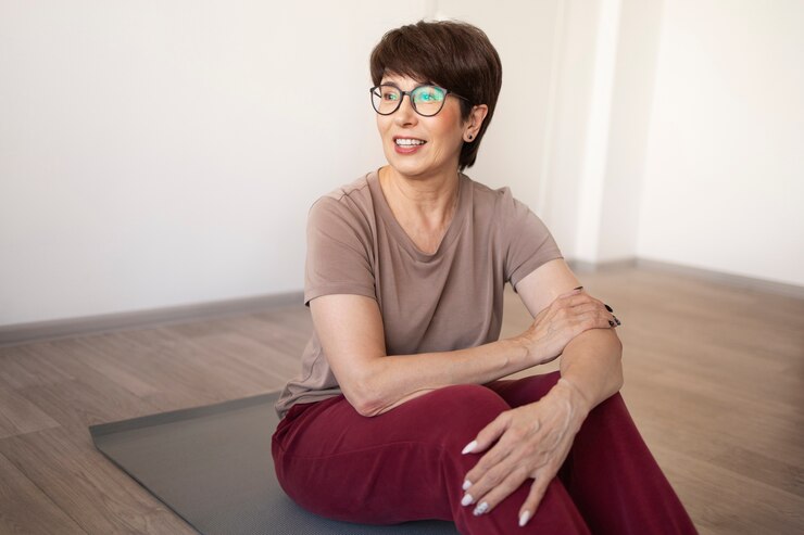 Mujer mayor haciendo yoga en casa