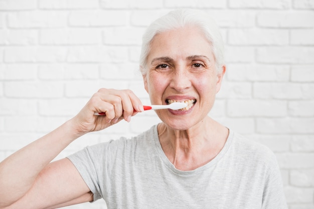 Mujer mayor lavándose los dientes