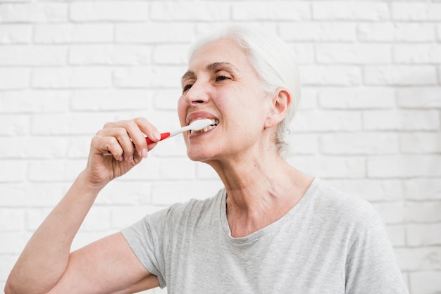 Foto gratuita mujer mayor lavándose los dientes