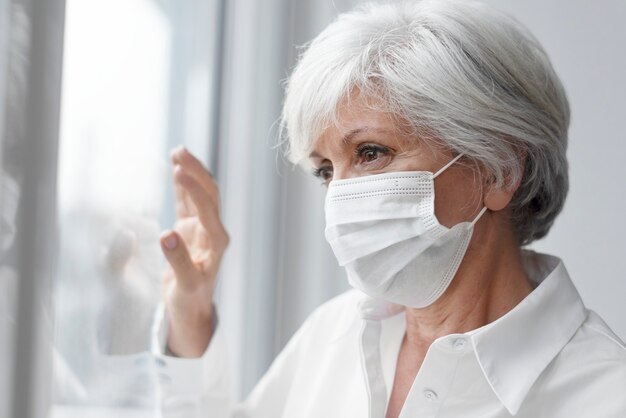 Mujer mayor, llevando, un, mascarilla facial, durante, en casa