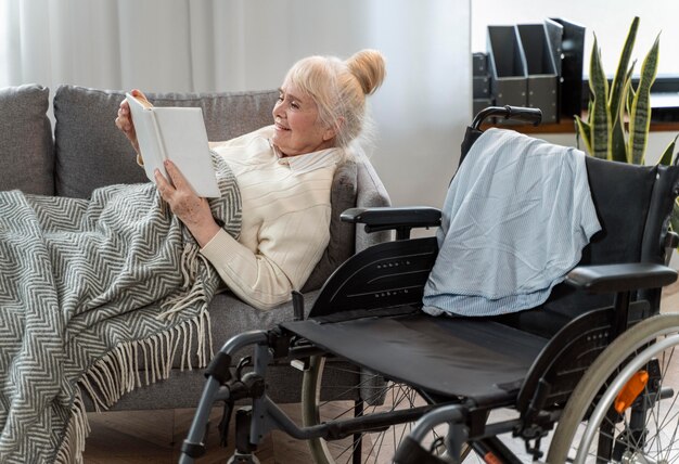Mujer mayor, mentira en cama, al lado de, un, silla de ruedas