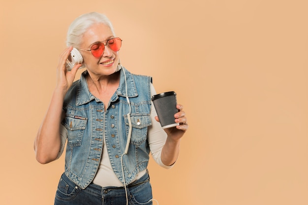 Foto gratuita mujer mayor moderna con gafas de sol