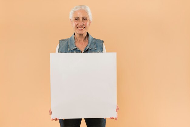 Mujer mayor moderna sujetando plantilla de tabla