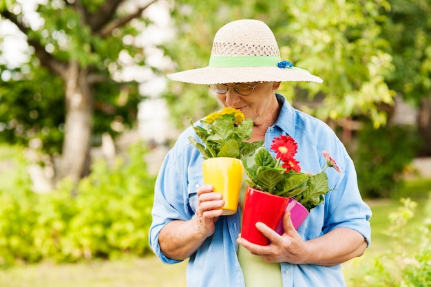 Mujer mayor, oler, flores