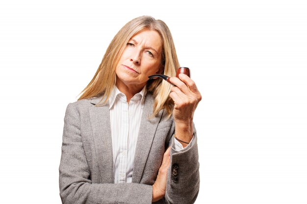 Mujer mayor pensativa con una pipa