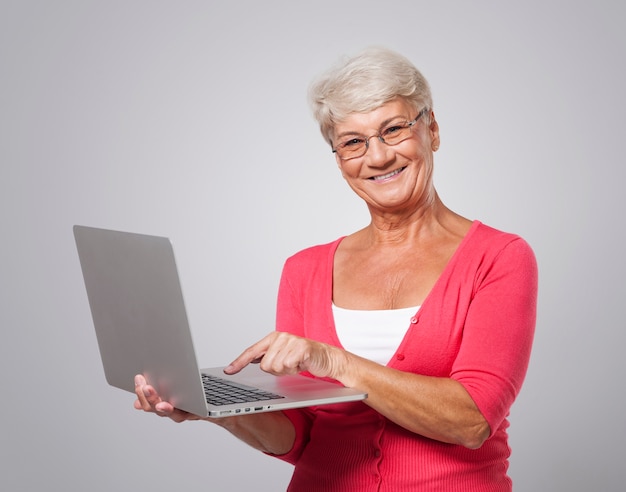 Mujer mayor con portátil contemporáneo