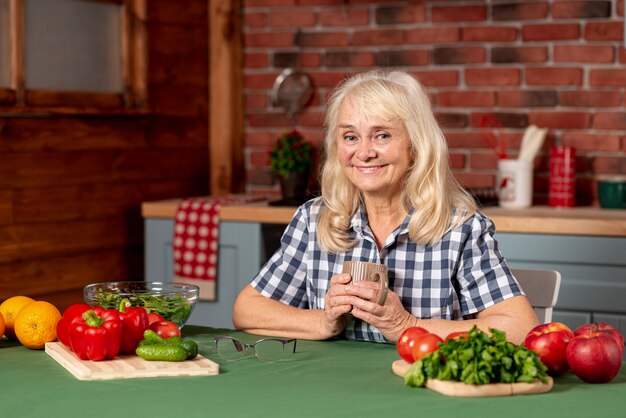 Mujer mayor que cocina la comida sana