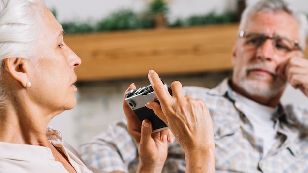 Mujer mayor que toma la foto de su marido de la cámara