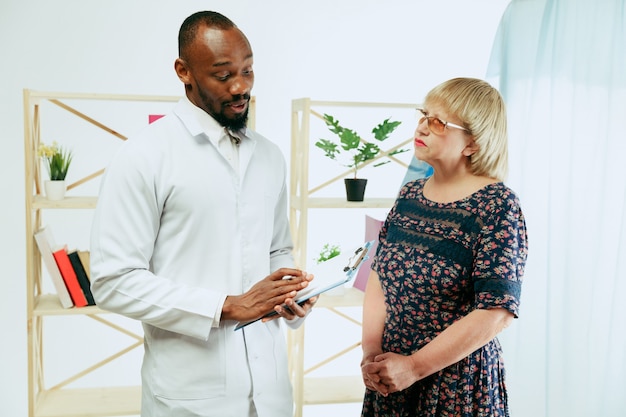 Una mujer mayor que visita a un terapeuta en la clínica para obtener una consulta y controlar su salud.