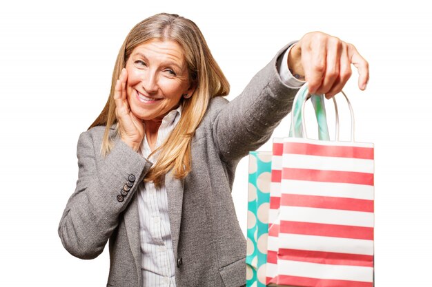 Mujer mayor sonriendo con bolsas de la compra