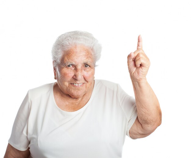 Mujer mayor sonriendo con un dedo levantado
