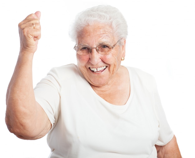 Mujer mayor sonriendo con un puño levantado