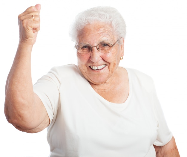 Mujer mayor sonriendo con un puño levantado