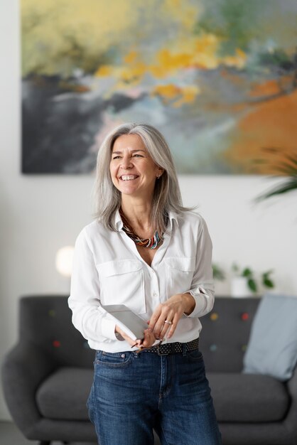 Mujer mayor sonriente de tiro medio en el interior