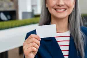 Foto gratuita mujer mayor, tenencia, tarjeta comercial en blanco