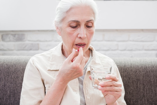 Foto gratuita mujer mayor tomándose sus medicinas