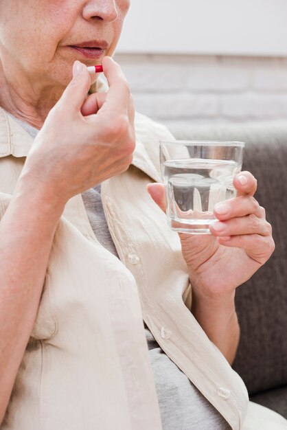 Mujer mayor tomándose sus medicinas