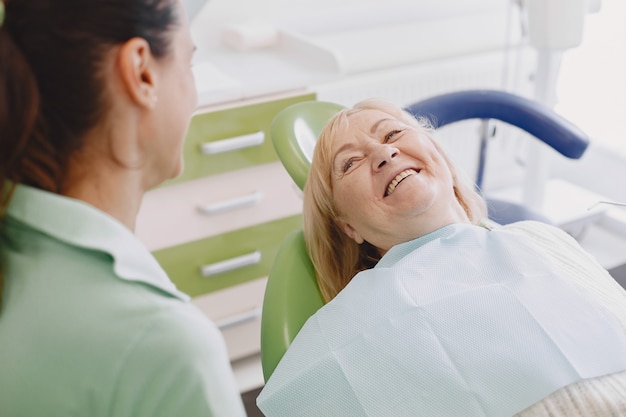 Mujer mayor con tratamiento dental en el consultorio del dentista. La mujer está siendo tratada por los dientes