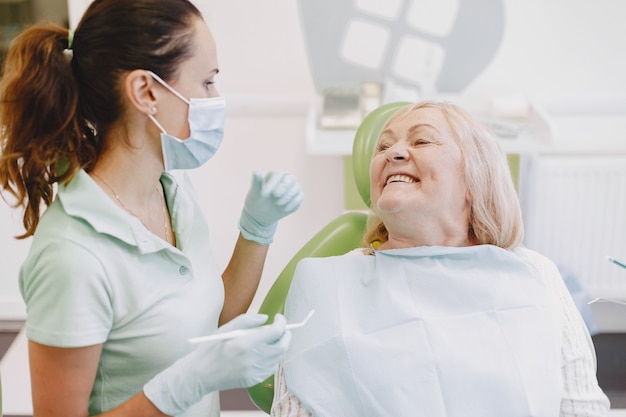 Mujer mayor con tratamiento dental en el consultorio del dentista. La mujer está siendo tratada por los dientes