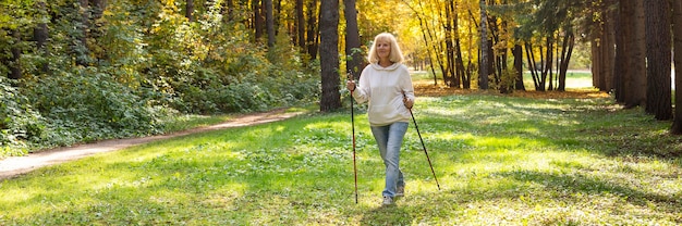 Mujer mayor trekking afuera en la naturaleza