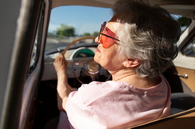 Mujer mayor viajando en coche durante el día