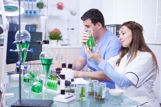 Mujer de mediana edad con su asistente trabajando en un laboratorio de investigación de microbiología. Tubos de ensayo.