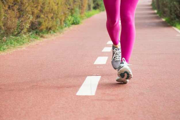 Mujer con medias rosas y zapatillas grises.