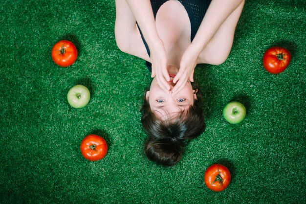 Mujer en medio de manzanas y tomates