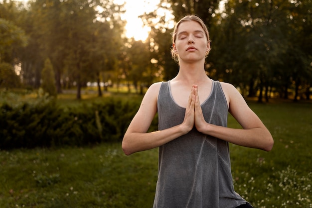 Mujer meditando al aire libre vista frontal