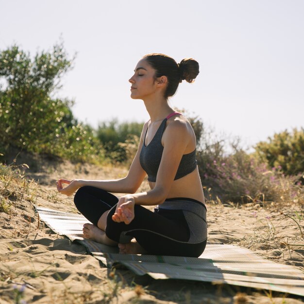 Mujer meditando en la arena