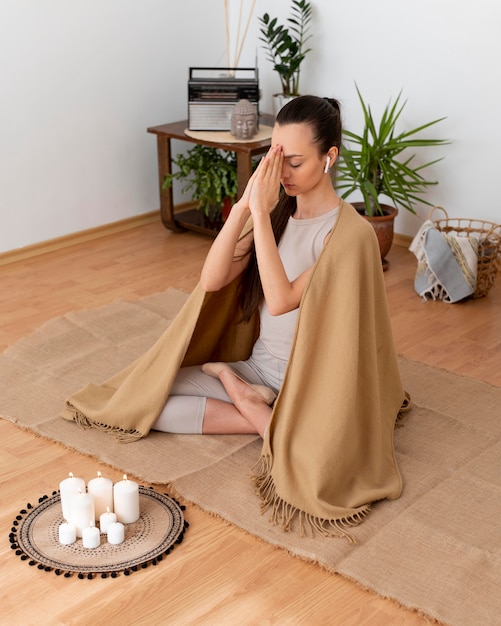 Mujer meditando con bandeja con velas