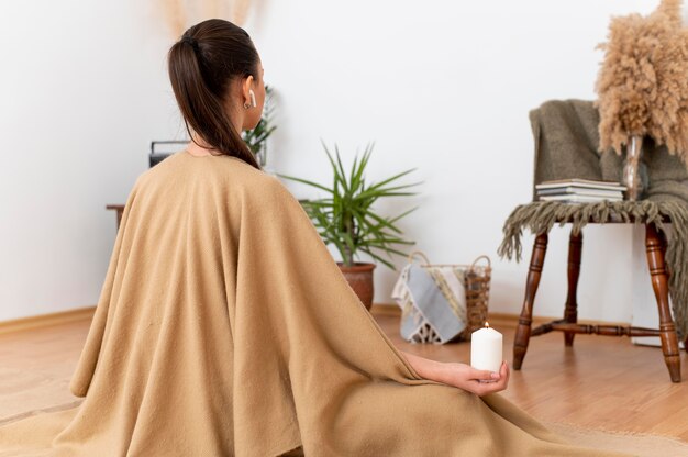 Mujer meditando con bandeja con velas