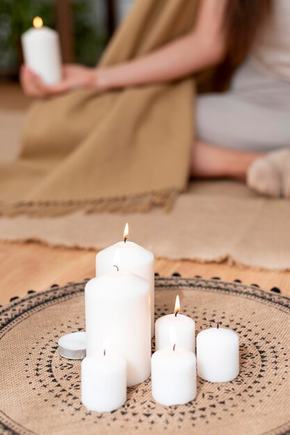 Mujer meditando con bandeja con velas