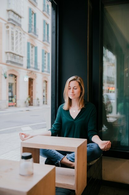 Mujer meditando en café