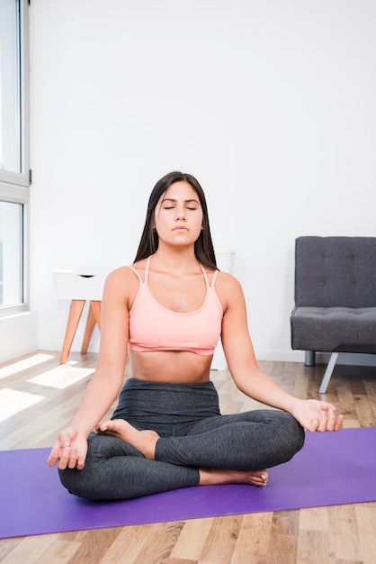 Mujer meditando en casa