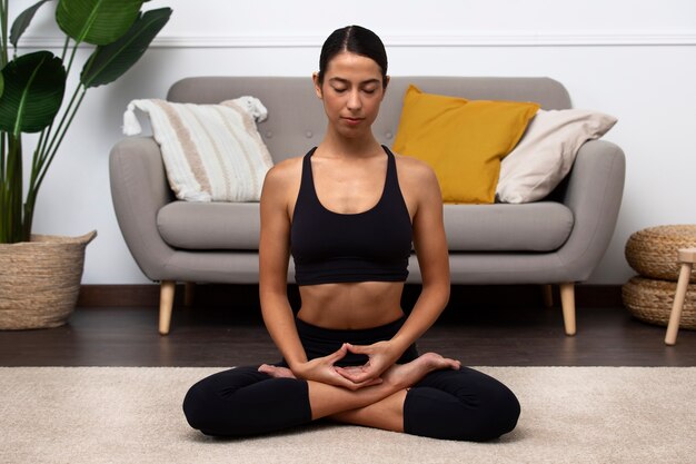 Mujer meditando en el interior tiro completo