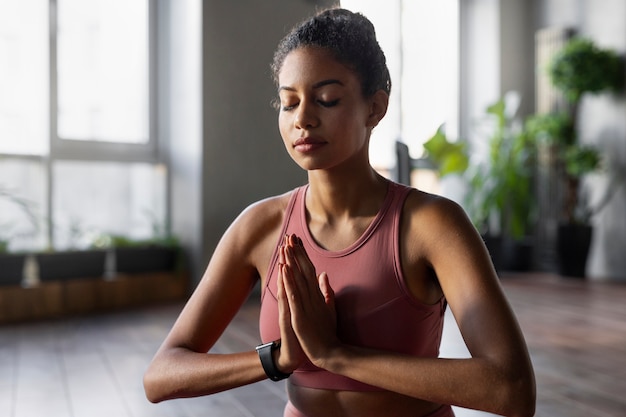 Foto gratuita mujer meditando en interiores tiro medio