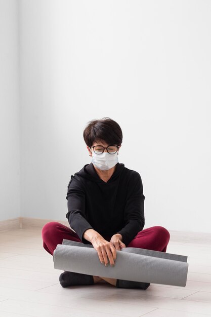 Mujer meditando mientras usa una mascarilla