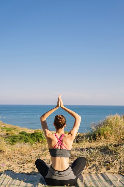 Mujer meditando mirando hacia el mar