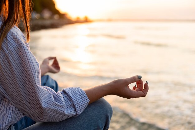 Mujer meditando en la playa con espacio de copia