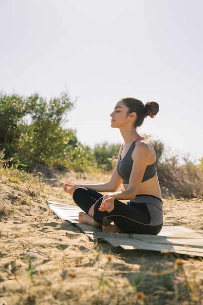 Foto gratuita mujer meditando por la playa