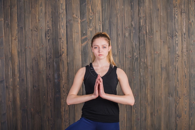 Mujer meditando sobre fondo de madera