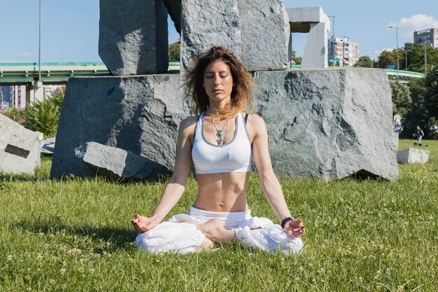 Mujer meditando sobre hierba