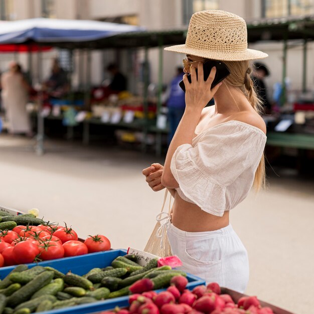 Mujer en el mercado hablando por teléfono