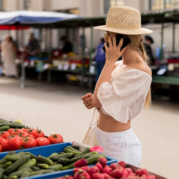 Mujer en el mercado hablando por teléfono