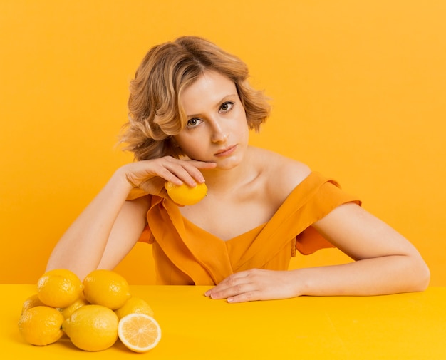 Mujer en la mesa con limones