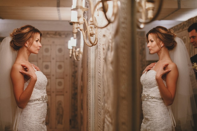 Foto gratuita mujer mira su vestido de novia en el espejo